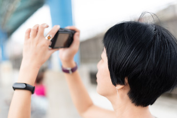 mature Asian woman using digital camera