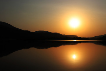 Sunrise over the lake among the hills