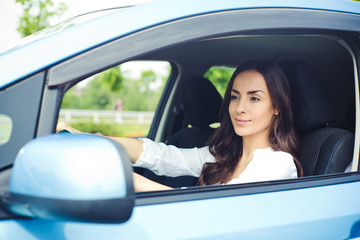 Cute young success happy brunette woman is driving a car. After dealership. Work auto. Vehicle of future 