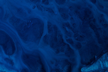 Abstract dark blue color gradient background. Acrylic paints texture pattern. Liquid fluid flowing covering rough surface.
