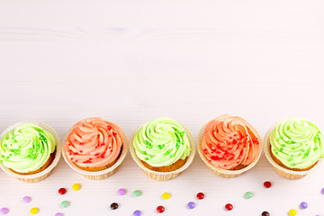 Tasty colorful cupcakes closeup on bokeh background with copy space. Birthday party sweets