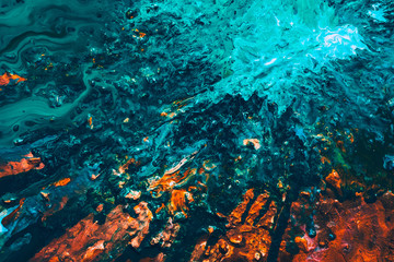 Abstract art texture background. Ocean waves splashing at cliff. Beautiful teal blue and orange paint mixture splotch.