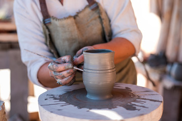 Potter is creating earthenware on potter's wheel.