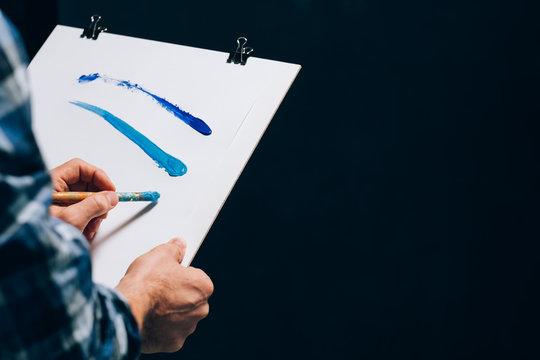Artist painting. Board panel in man hands. Sudden inspiration creativity artistry. Guy making paint brush strokes on paper.