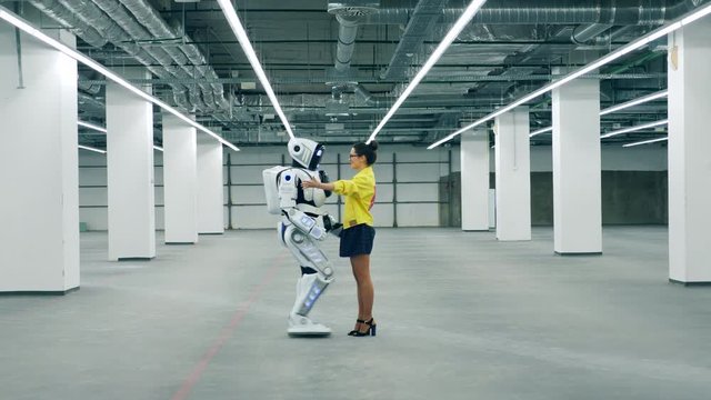 A woman hugs meets her friend robot, hugging it.