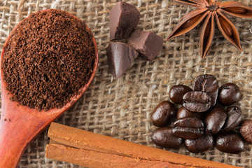 Freshly hot brewed coffee. Coffee beans, cinnamon and anise stars on a dark wooden background