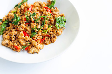 Stir-fried hot and spicy pork with holy  basil on white.