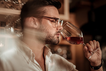 Focused photo on relaxed man that enjoying red wine