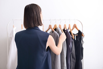 Stylish young woman choosing clothes in her dressing room at home