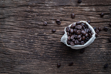 Obraz na płótnie Canvas wood table with fresh coffee bean in Cloth sack.