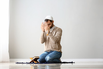 Fototapeta premium Young Muslim man praying indoors