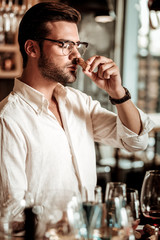 Portrait of handsome sommelier that smelling cork