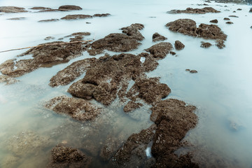 Long Exposure Photography of Waves on stone beach waters edge abstract sea background.Thailand.