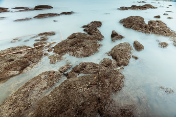 Long Exposure Photography of Waves on stone beach waters edge abstract sea background.Thailand.