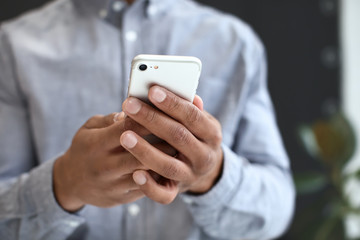 African-American man with mobile phone in office, closeup