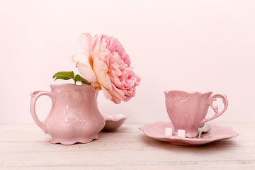 Big roses and coffee on a white wooden background.