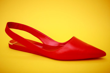 Red woman shoes isolated on the yellow background.