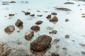 Long Exposure Photography of Waves on stone beach waters edge abstract sea background.Thailand.