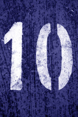 Number 10 in stencil on metal wall in blue tone.