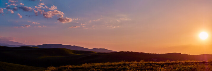 Panorama of a mountain valley in summer. Fabulous sunset in the mountains, amazing nature, summer in the mountains. Travel and camping, tourism