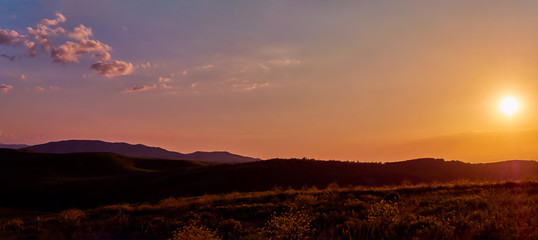 Panorama of a mountain valley in summer. Fabulous sunset in the mountains, amazing nature, summer in the mountains. Travel and camping, tourism