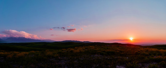 Panorama of a mountain valley in summer. Fabulous sunset in the mountains, amazing nature, summer in the mountains. Travel and camping, tourism