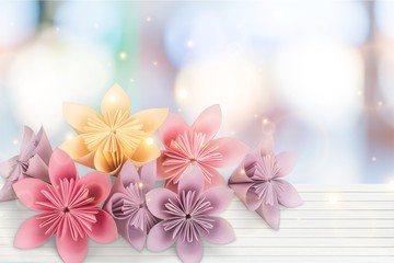 Color Origami flowers on abstract bokeh background