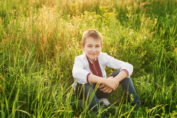 Fototapeta premium Ukraine's Independence Day. Child boy in an embroidered shirt in field. Ukraine in field. Child kozak. Patriot child.