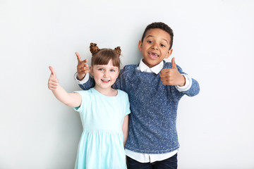 Portrait of cute children showing thumb-up on white background