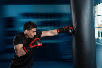 Eastern Arab boxer looks at the box with a punching bag.