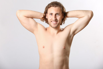 Fototapeta premium Naked young man after epilation on light background