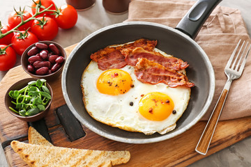 Traditional English breakfast with fried eggs, bacon, beans and toasts on table