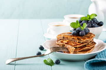 Delicious pancakes with chocolate drops, honey and blueberries. Healthy breakfast concept with copy space.