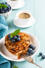 Delicious pancakes with chocolate drops, honey and blueberries. Healthy breakfast concept with copy space. High angle view