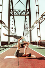 People doing an acrobatic exercise on a pedestrian bridge
