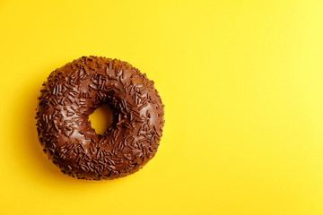 chocolate donut on yellow background top view