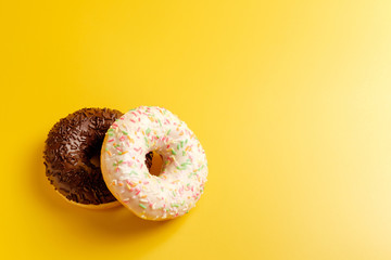 two black and white donuts on yellow background top view