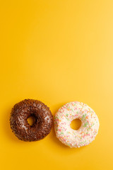 two black and white donuts on yellow background top view