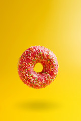 pink donut on yellow background