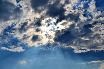 Naklejka na ściany i meble Sunbeam piercing through the clouds. Rays of sunshine breaks through the dark clouds. Faith symbol. Hope, faith, optimism concept