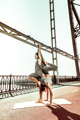 Fototapeta na wymiar Barefoot female yogi and her partner exercising outdoors