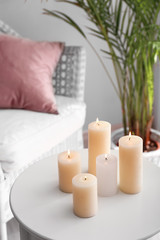 Fototapeta na wymiar Beautiful burning candles on table in room