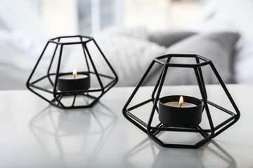 Beautiful burning candles on table in bedroom