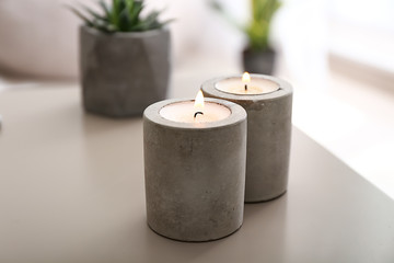 Beautiful burning candles on table in room