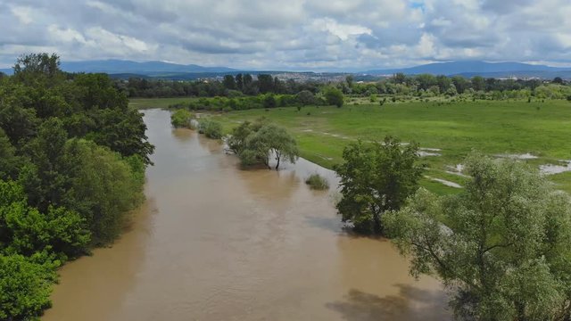 Rural village along river water at high levels with flooding meadows of the lower a cloudy sky Ukraine
