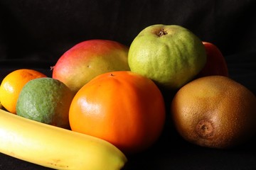 Closeup of Tripical fruits against black background - tropical still life,Fresh and healthy nutrition.