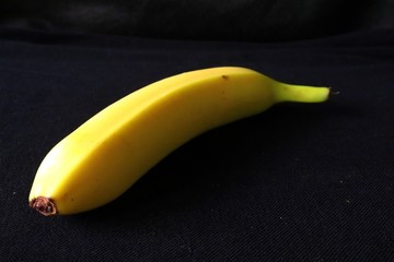 Single fresh Banana against black background