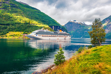 Sunny summer scene of Geiranger port, western Norway. Colorful view of Sunnylvsfjorden fjord....