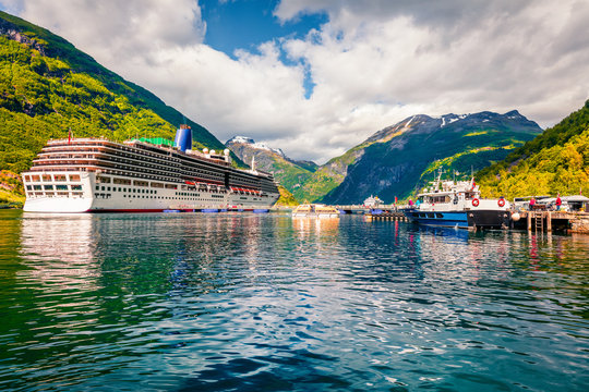 Sunny summer scene of Geiranger port, western Norway. Splendid view of Sunnylvsfjorden fjord. Traveling concept background. Artistic style post processed photo.