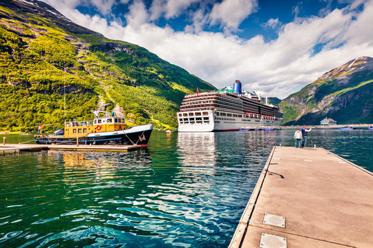 Sunny summer scene of Geiranger port, western Norway. Splendid view of Sunnylvsfjorden fjord. Traveling concept background. Artistic style post processed photo.